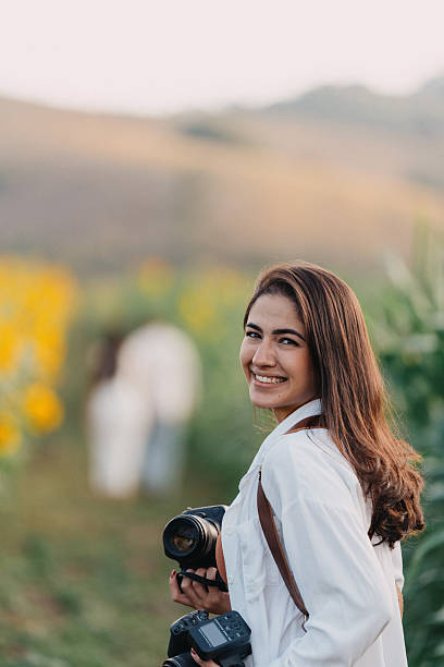 istock Smiling woman holding camera in nature 2225683373
