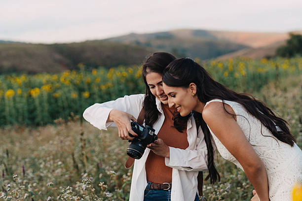 Two women reviewing camera screen outdoors
