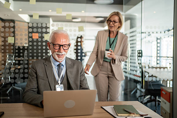 istock Senior businessman smiling while working on laptop in office 2225688288