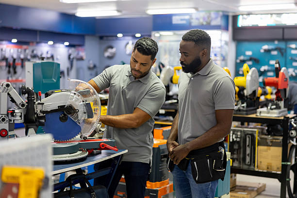 istock Manager training a new employee and showing him a machine at a hardware store 2225706034