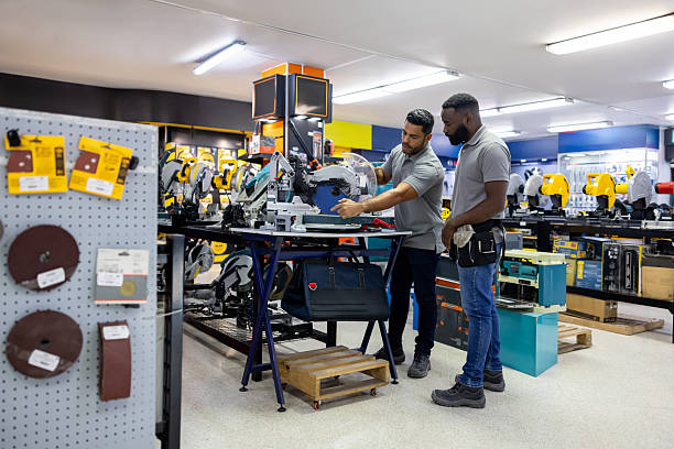 istock Hardware store worker training a new employee and showing him a machine 2225706052