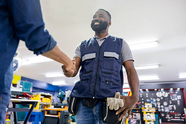 istock Retail clerk greeting a customer with a handshake at the hardware store 2225706145