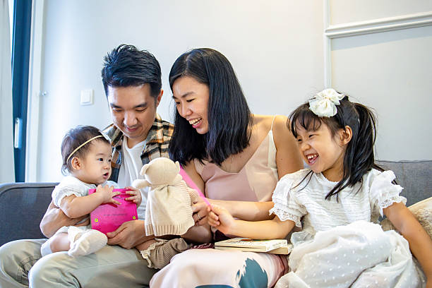 istock Daughters giggling with parents in cozy room. 2225712714