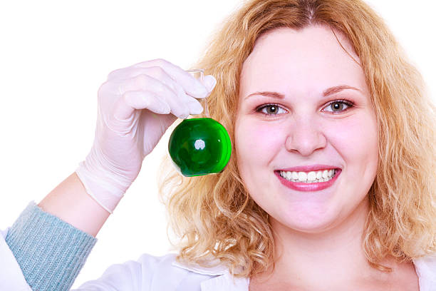 Science and education. Scientist at school laboratory. Happy girl holding chemical flask with green liquid. Student with beaker. Biology experiment, sample formula, chemistry research results.