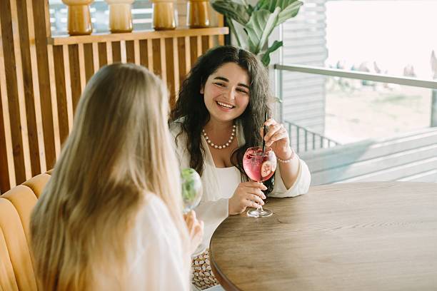 istock Two young women enjoying refreshing drinks at a cafe 2225731988