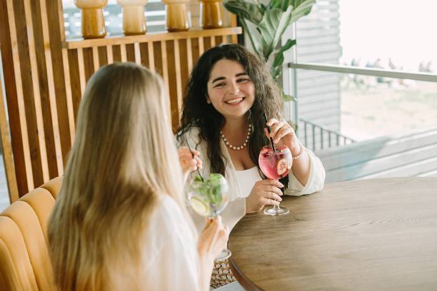 istock Two young women enjoying refreshing drinks at a cafe 2225731993
