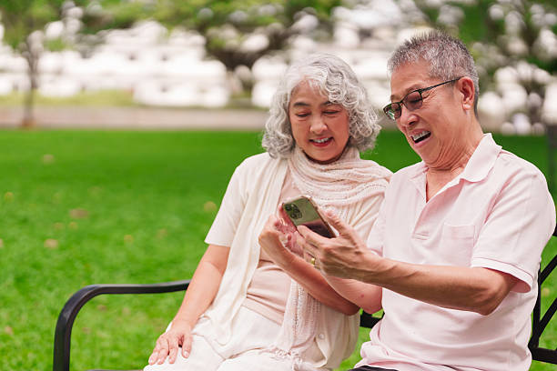 istock Asian Seniors Laughing Park Bench Using Smartphone Technology Connection Retirement Life 2225737564