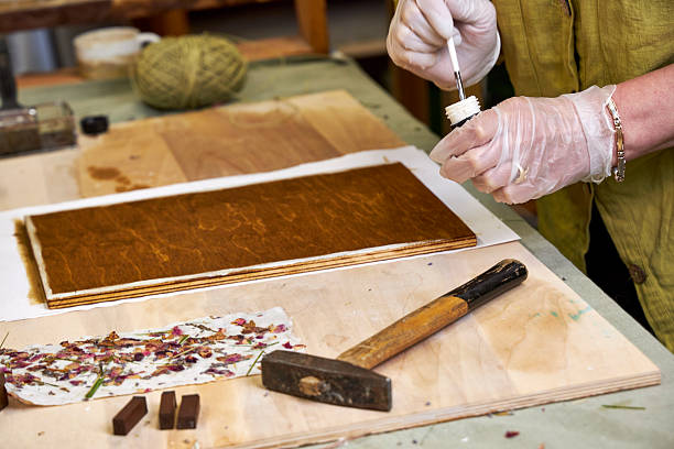 istock Brushing wood panel for decorative craft with handmade floral paper. Eco-friendly art project using natural materials and botanical paper. Creative DIY workspace 2225738840