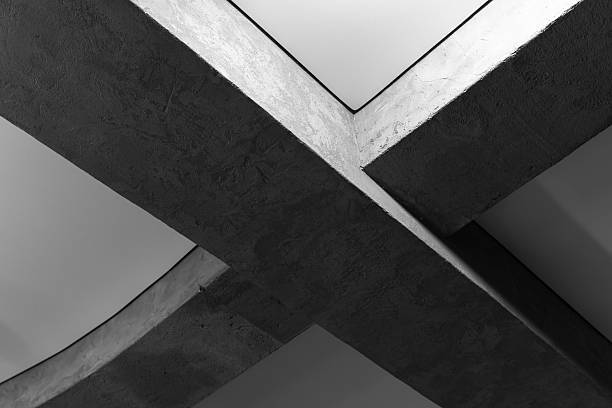 Abstract concrete architecture featuring crossing geometric shapes in black and white photography