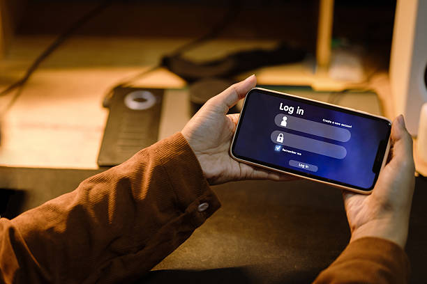 istock Man holding smartphone showing user login screen, about to access secure online account or service 2225742090