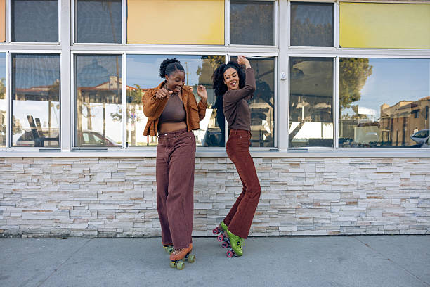 Two friends on roller skates enjoying a ride together.