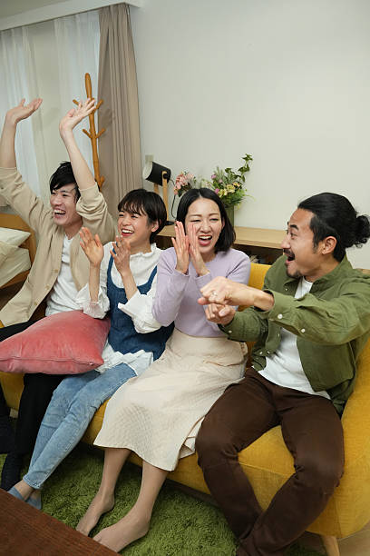 istock Four,friends,cheering,on,the,couch 2225748315