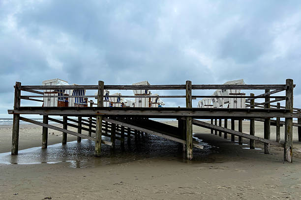 istock Wooden platform with cabins for relaxation during low tide by the sea 2225748710