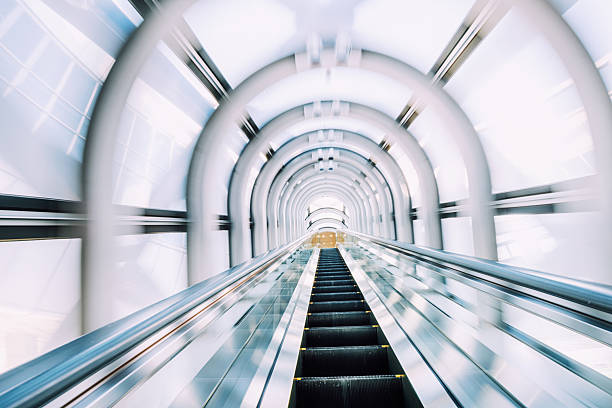 A dynamic perspective of a futuristic escalator surrounded by sleek, modern architectural elements, showcasing vibrant lighting and shiny surfaces.