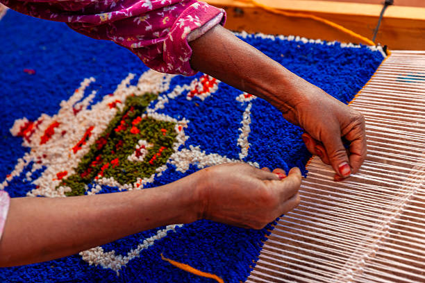 Berber woman weaving a carpet in a traditional house, Ouarzazate, Morocco. This old fashined form of weaving is very popular in the High Atlas mountains, specially in villages near Ouarzazate town.