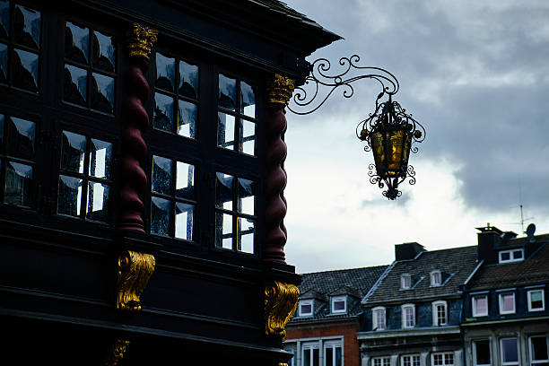 Ornate lantern and historical building facade at dusk, Aachen, Germany