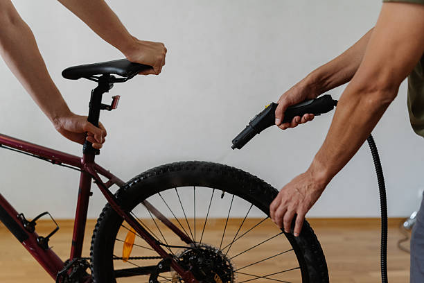 istock Two mechanics cleaning mountain bike wheel using steam cleaner, ensuring thorough maintenance and hygiene in professional workshop, close-up cropped shot. 2225755650