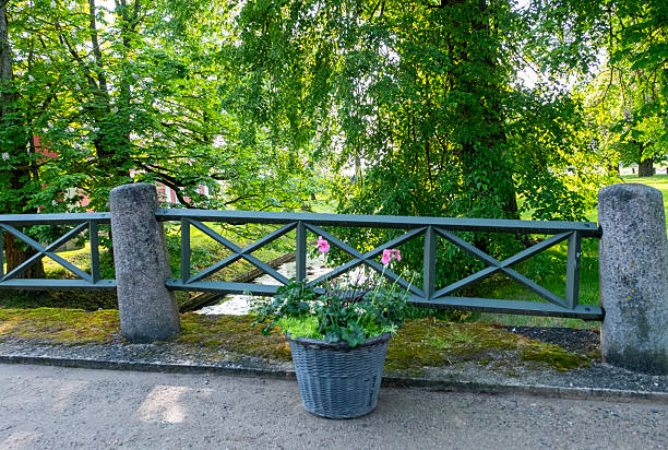 Latvia Pilsrundale. Pedestrian bridge over the canal and a flower bed.
