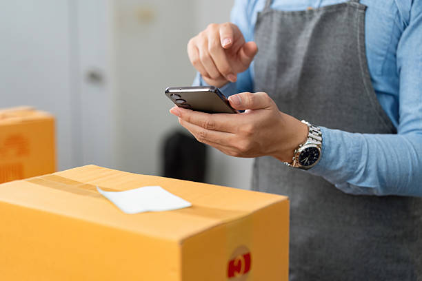 istock E-commerce logistics. A man using smartphone to manage packages and logistics. 2225760737