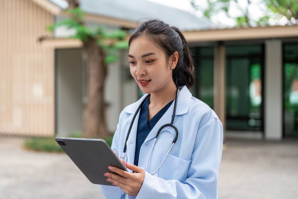 istock Doctor in lab coat using tablet outdoors, modern healthcare 2225762208