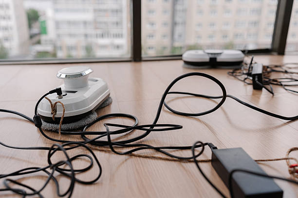 istock Window cleaning robots resting on floor, plugged into power strip, charging before window-washing operation. 2225768898