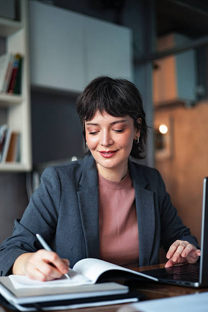 istock Professional Woman Writing Notes at Workstation in Modern Office 2225770307