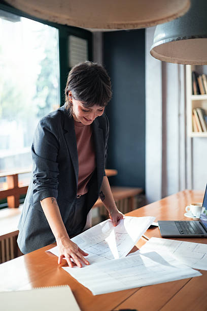 istock Architect Reviewing Plans in Modern Office Interior with Natural Light 2225770367