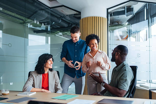 istock Team of Four Colleagues Collaborating and Smiling in a Modern Office Setting 2225770838