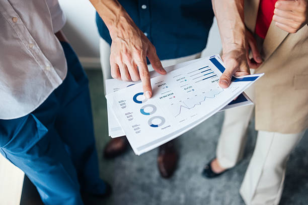 Business Team Discussing Graphs and Charts Together in an Office Environment