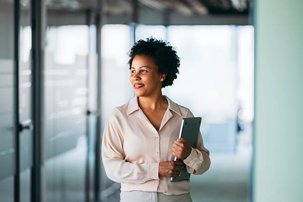 istock Confident Businesswoman Holding Tablet and Smiling in Modern Office Setting 2225770937