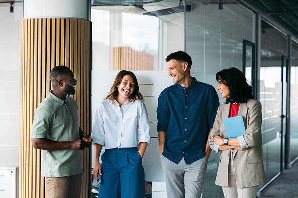 istock Group of Colleagues Engaging in Friendly Conversation in a Modern Office Setting 2225770942