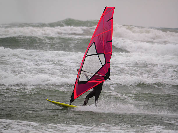 istock Water Sport Activity - Windsurfer Riding a Wave in Rough Sea on a Windy Day 2225772118