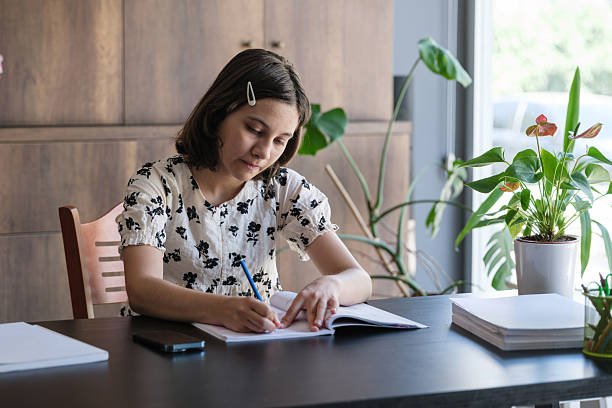 istock Adolescence girl doing her homework at home 2225773186