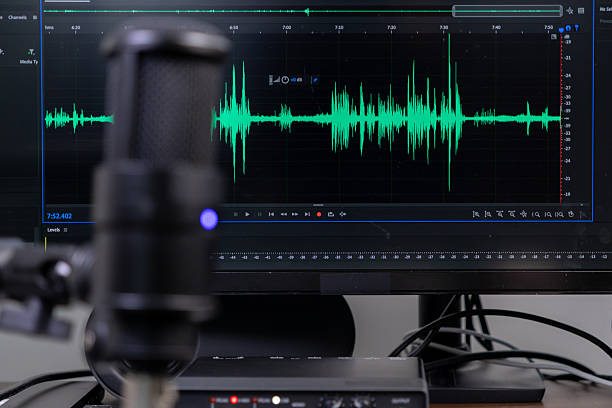 istock Studio microphone and monitor displaying green audio waveform for professional sound recording, podcast creation, and digital content 2225775299