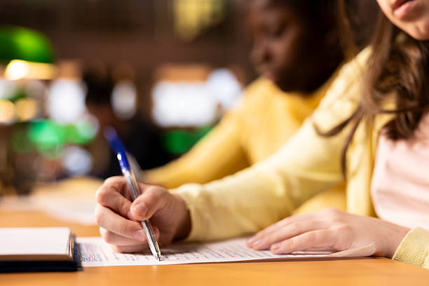 istock Multiethnic teens finishing their homework at a library after classes 2225777699