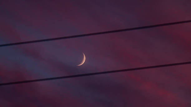 Pink sky with clouds and a new moon. Sky with the moon at sunset