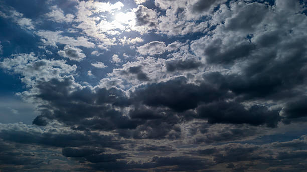 istock Dramatic clouds covering the sky, with sunlight breaking through. The scene depicts the beauty of nature during the day, showcasing varying shades of gray and blue in the sky. 2225779875