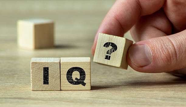 istock A hand holding a wooden block with an IQ question mark, symbolizing intelligence and cognitive assessment in a minimalistic setting with natural light. 2225780069