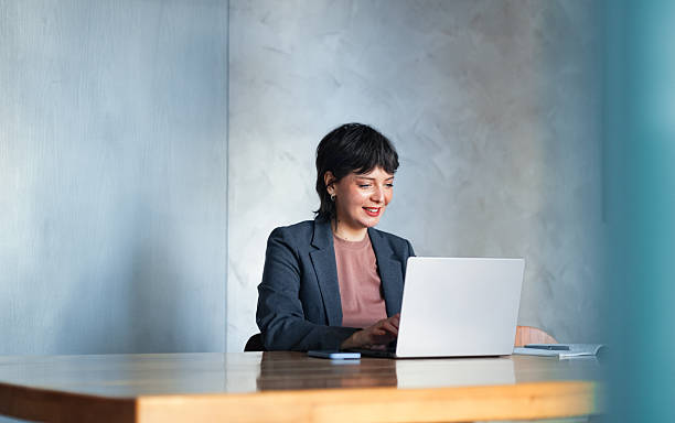 Professional Businesswoman Working on a Laptop in a Modern Office Setting