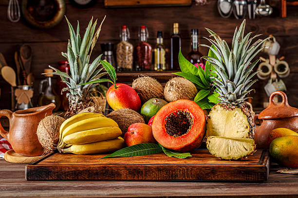 istock Tropical fruits and vegetables on rustic wooden table. Natural window lighting 2225781684