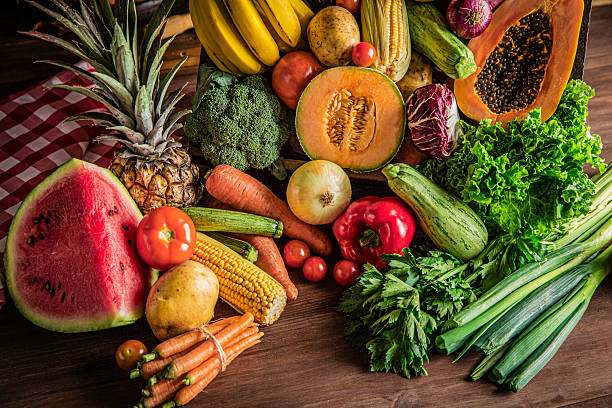 istock Tropical fruits and vegetables on rustic wooden table. Natural lighting 2225781765
