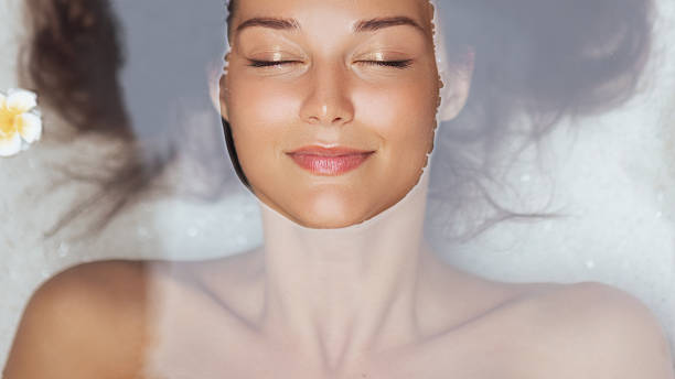 istock Blissful Woman Relaxing In Bath With Face Emerging From Calm Water 2225781910