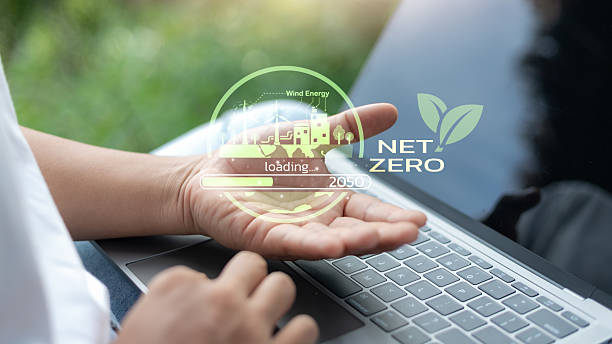 istock Hand showing Net Zero 2050 concept with wind energy, eco factory, green technology loading interface, sustainable development goal, and clean energy transformation for the environment. 2225783369