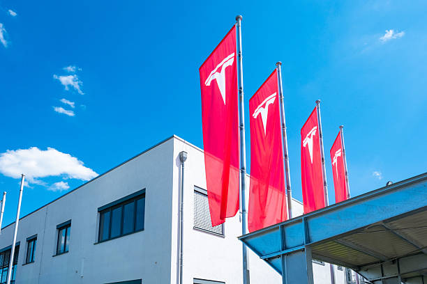 Prominent Red Tesla flags with logo on display, office building with company banners, Corporate branding, ev innovation, sustainable energy and automotive technology, Giessen, Germany - June 28, 2025