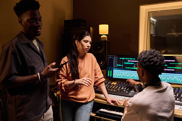 istock Multiethnic Young Adults Collaborating in Music Recording Studio 2225793979