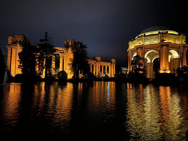 Night photo of Palace of Fine arts in golden light with reflection of palace in water.  San Francisco, USA - November 11, 2024