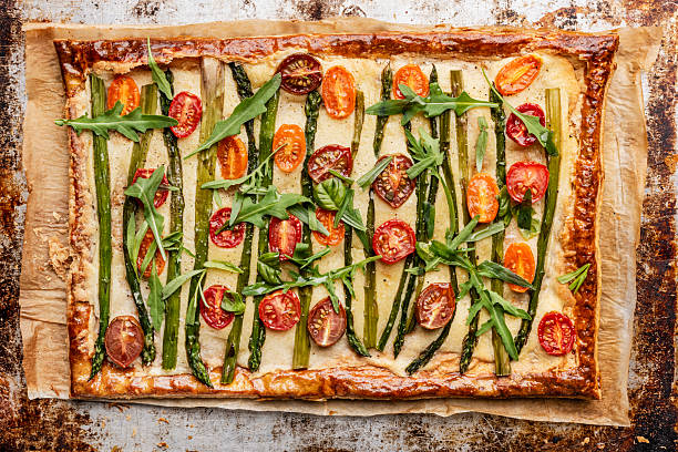 Vegetarian savoury frangipane tart. Topped with cherry tomatoes, arugula and asparagus.