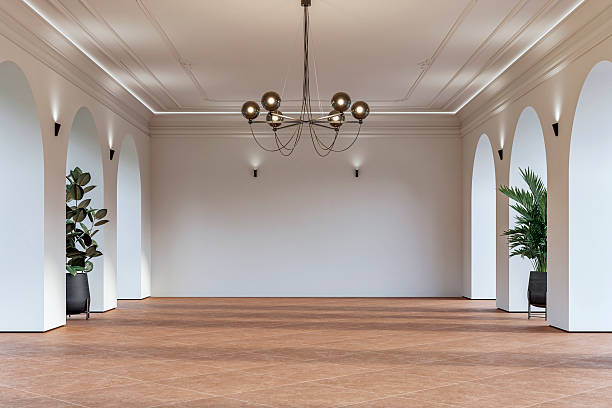 istock Modern empty interior with elegant arched openings, decorative ceiling molding, chandelier and decorative potted plants on orange ceramic floor 2225804855
