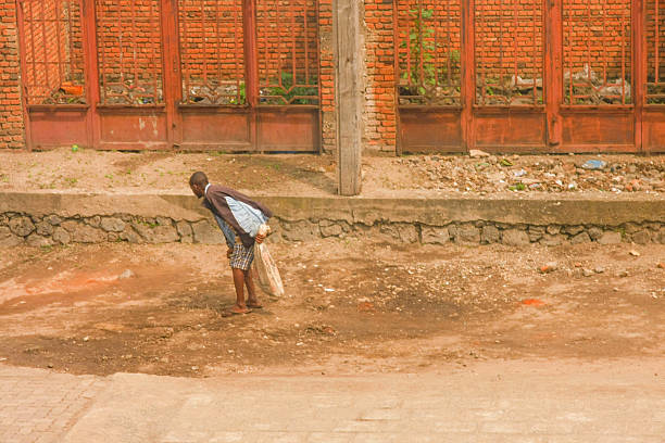 village single african happy child boy sited in front of the house , in the yard, with a smile