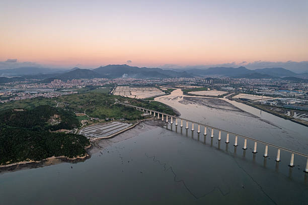 istock Dawn light on a causeway rail bridge over tidal mud. 2225807068